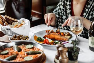 Une femme élégante savourant une pâtisserie salée en terrasse, une scène typique d'un restaurant Porte Saint-Denis